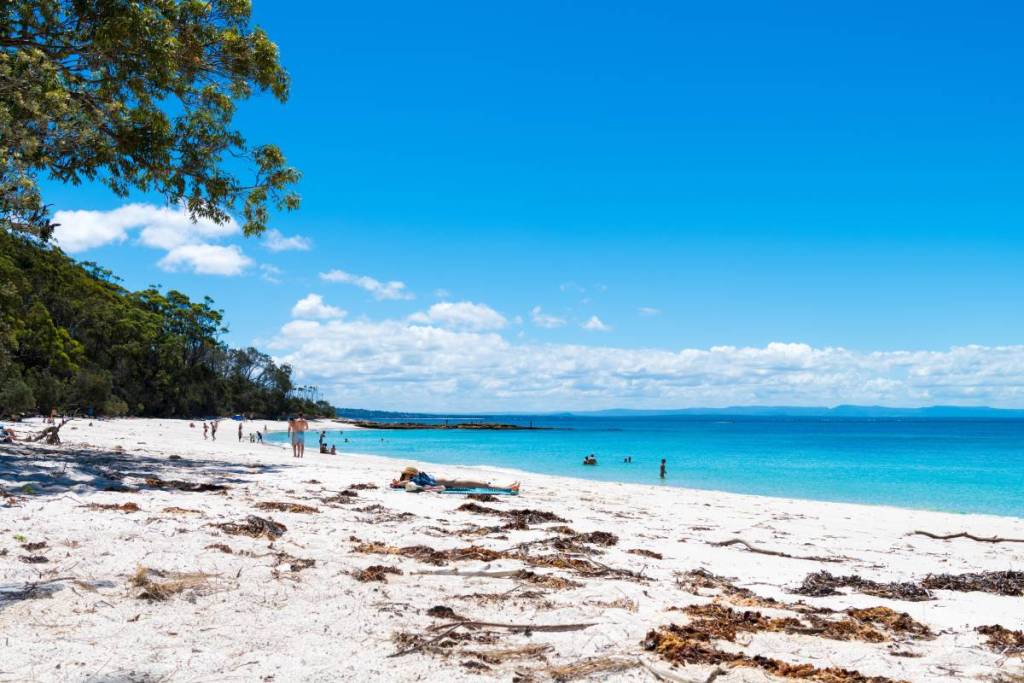 Secluded white sand beach with crystal-clear turquoise water and native bushland at Booderee National Park, Jervis Bay