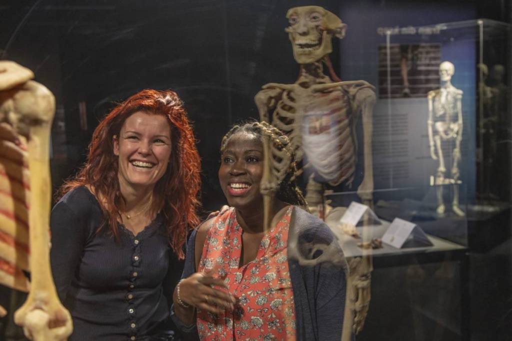 Two woman gaze at a skeleton at BODY WORLDS.