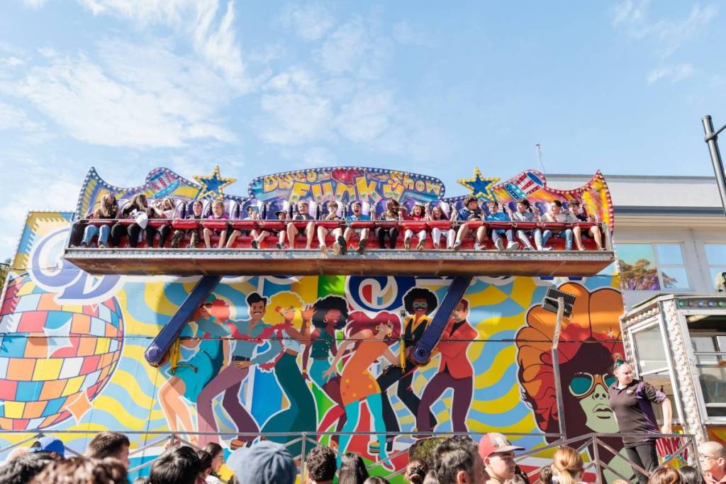 People enjoying a carnival ride at the Ferragosto Italian Street Festival in Five Dock, Sydney
