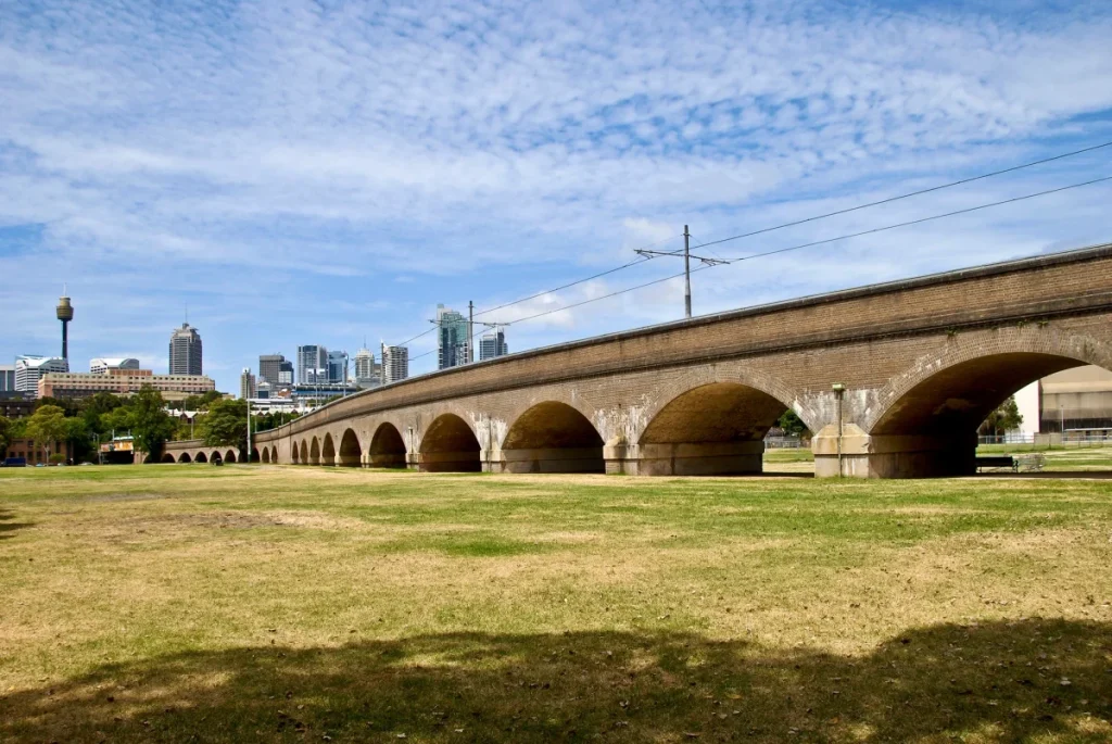Wentworth Park in inner Sydney, with the historic viaduct, open green space and Sydney skyline in the background