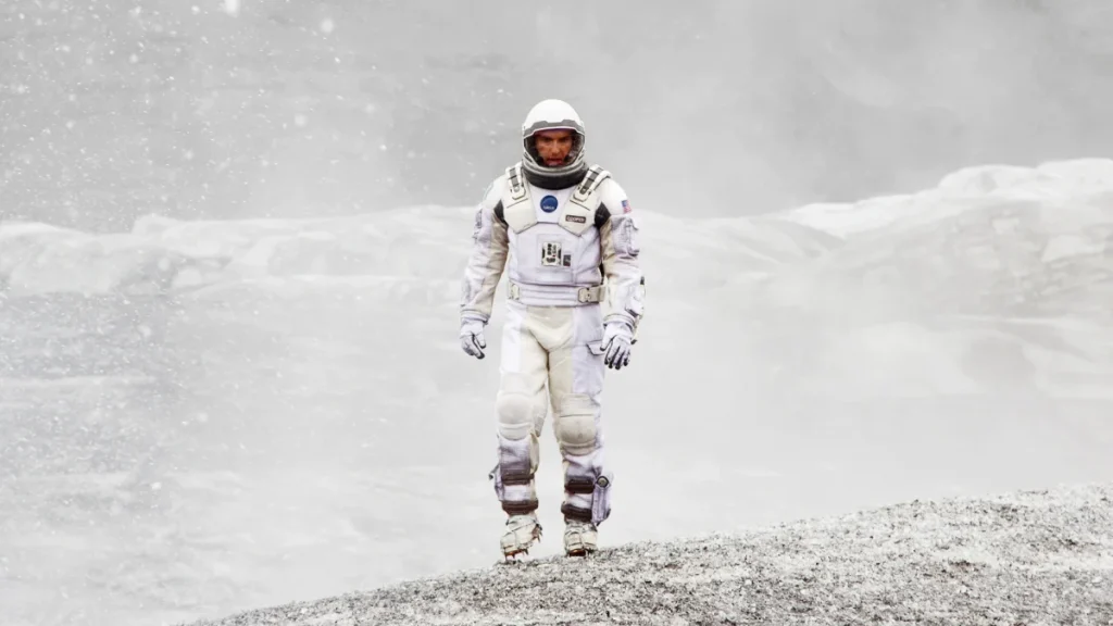 Matthew McConaughey as Cooper walking across an icy alien planet in Interstellar