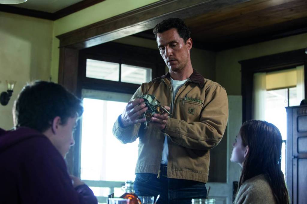 Matthew McConaughey as Cooper holding a model spacecraft while speaking to his children in a scene from Interstellar