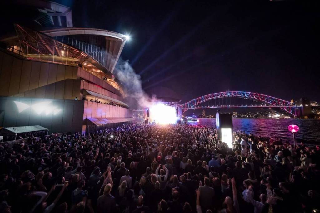 people gathered at night near the Sydney Opera House Northern Broadwalk