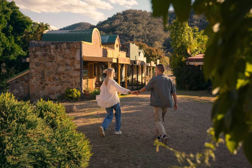 Visitors strolling past heritage shopfronts on Sofala's historic main street in NSW