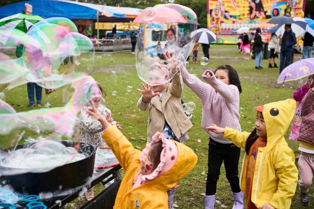 Children play with giant bubbles at the Strathfield Spring Festival in Sydney