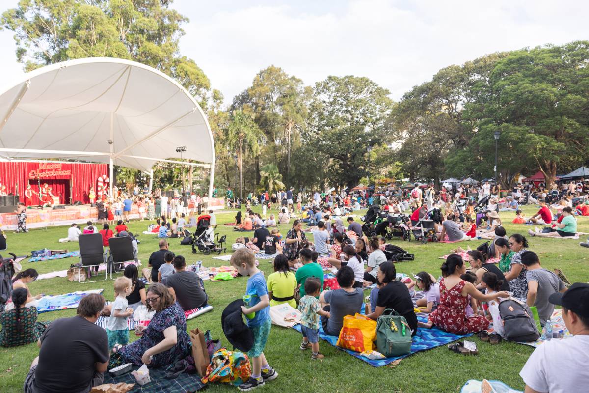 Families enjoying live entertainment and market stalls at an outdoor festival in Sydney