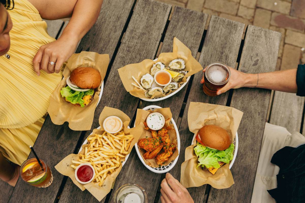 Burgers, oysters, fries and drinks served at an outdoor table in Merimbula