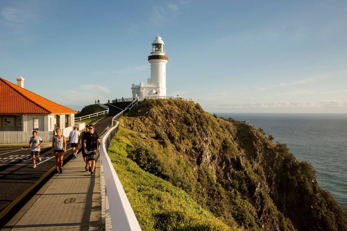 Cape Byron Lighthouse overlooking the ocean with walkers on the path below