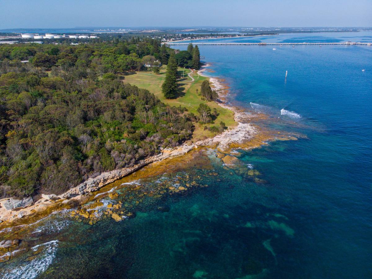 Aerial view of the rugged coastline and blue waters of Kamay Botany Bay National Park