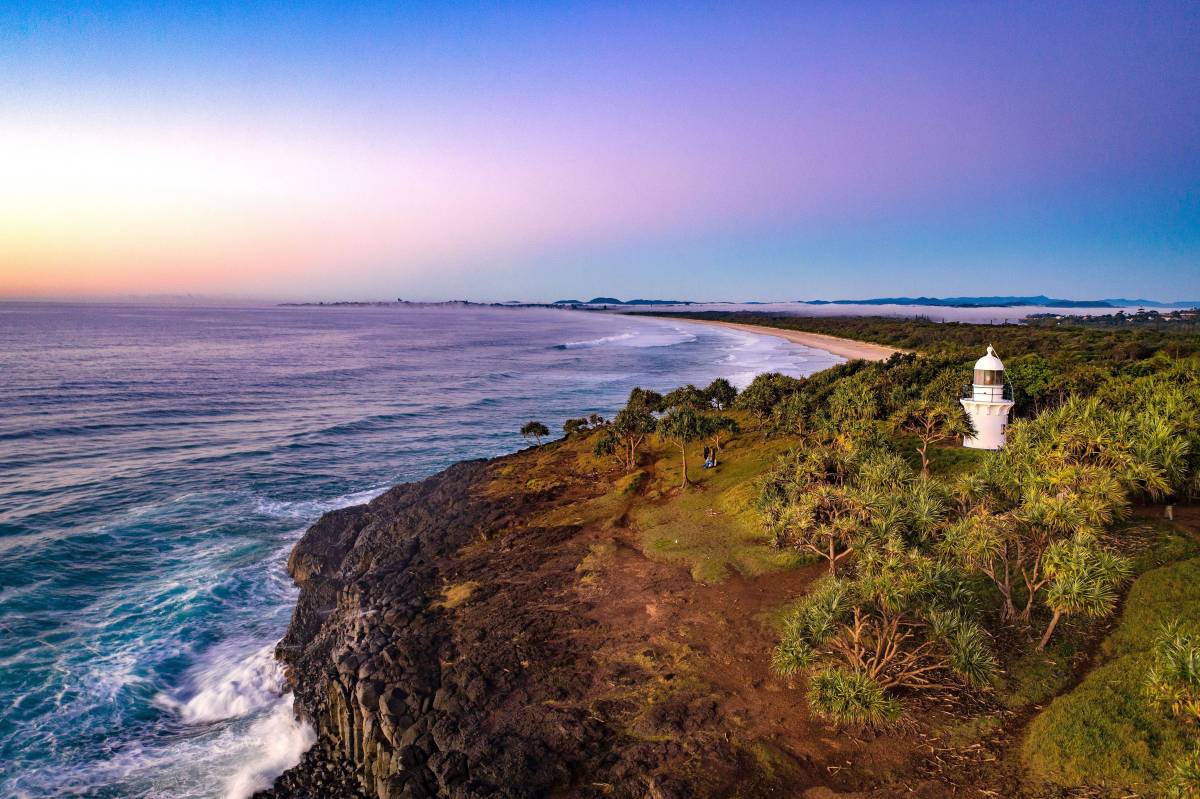 Fingal Head Lighthouse overlooking the rugged coastline and Pacific Ocean at sunset