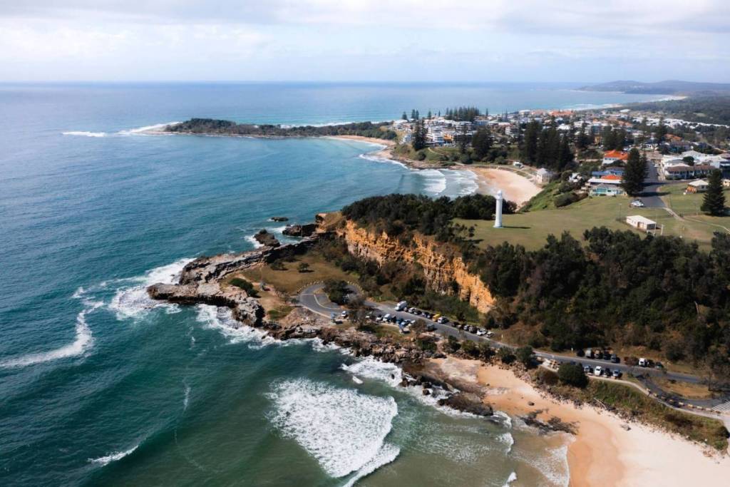 Aerial view of Yamba's coastline, beaches and lighthouse overlooking the turquoise ocean in NSW