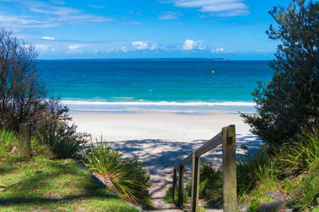 White sand beach and vivid turquoise-blue water framed by coastal bushland in Jervis Bay