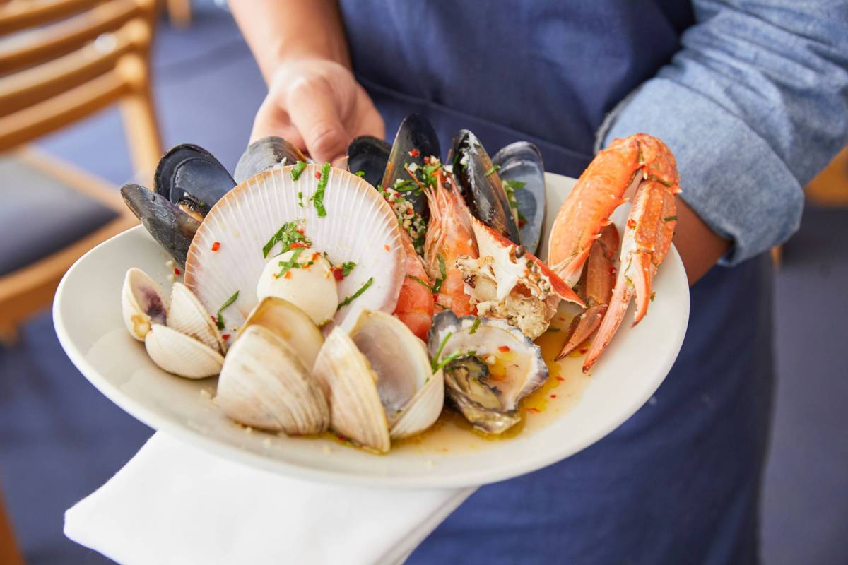 A freshly prepared seafood platter featuring prawns, mussels, oysters, scallops, clams and crab, served at a waterfront restaurant in Mollymook