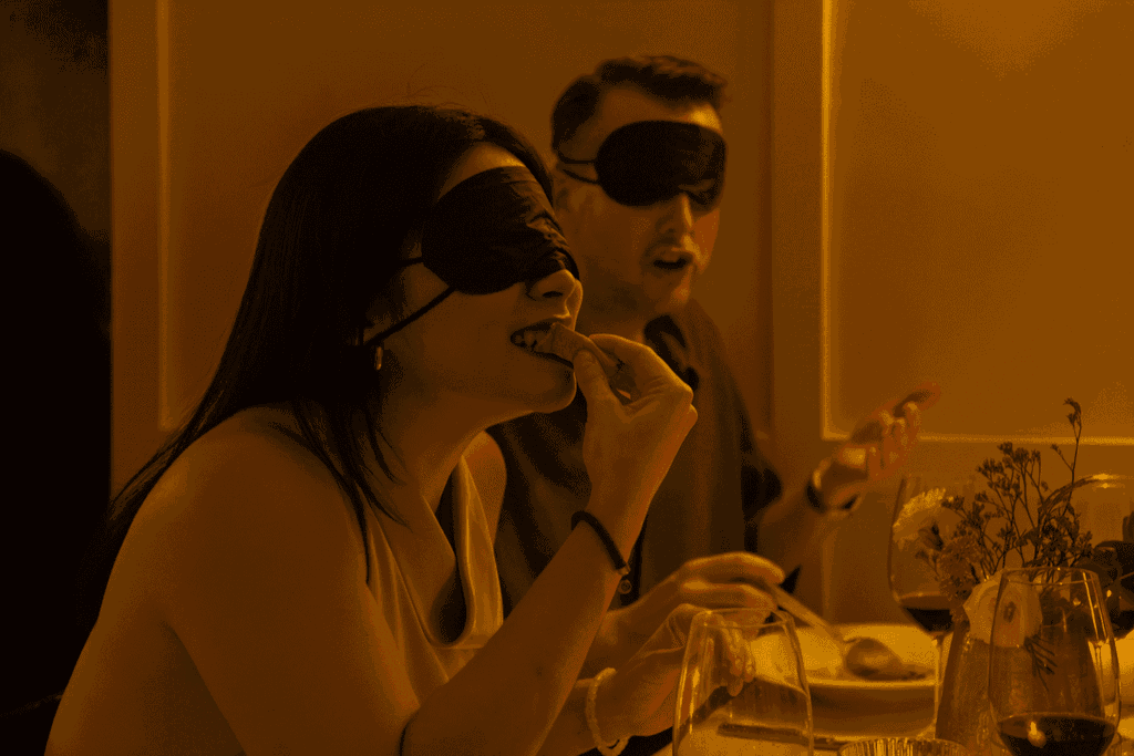 Two diners eating dinner blindfolded at Dining in the Dark