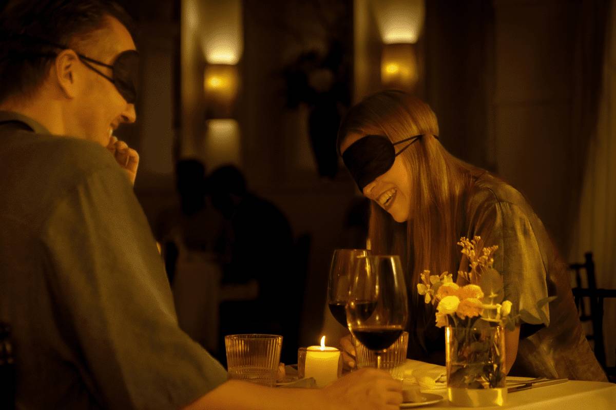 A woman laughing while blindfolded at Dining in the Dark