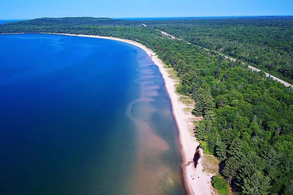 Cette plage ontarienne méconnue, avec ses 3 km de sable blanc et ses eaux bleues cristallines, est la destination idéale pour un road trip estival au départ de Toronto