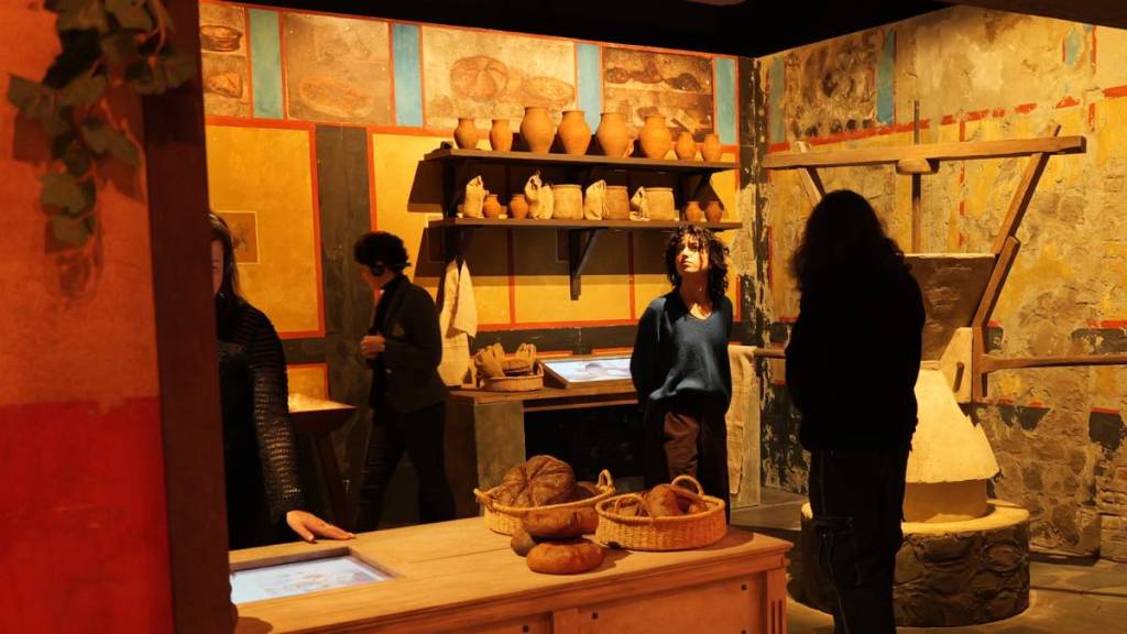 Visitors of Back to Pompeii looking at a kitchen typical of Pompeii prior to 79 AD