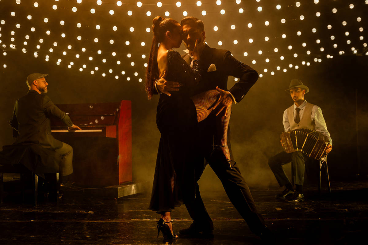 Un pianista, un bandoneonista y una pareja de bailarinas interpretando una pieza de tango