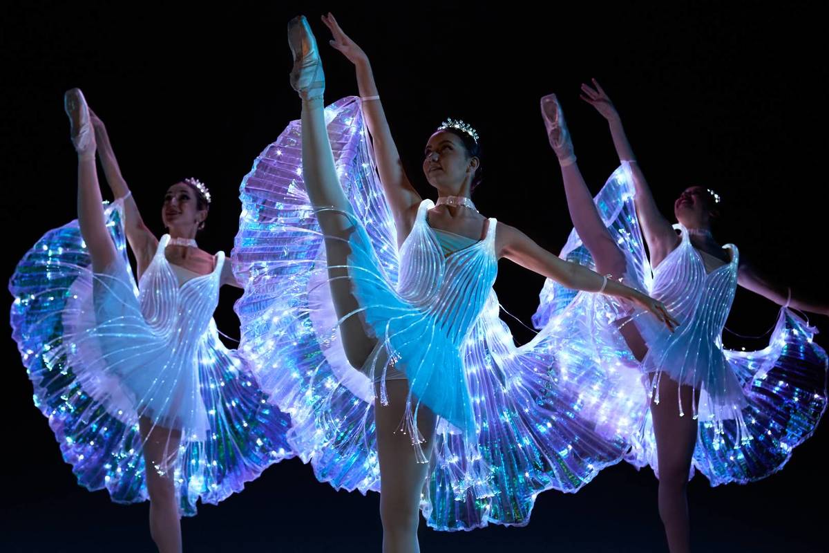 Tres bailarinas con trajes iluminados bailen en Ballet of Lights.