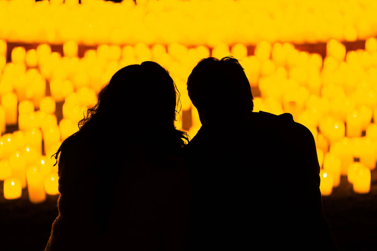 Una pareja mira hacia un escenario cubierto de cálidas velas durante un concierto Candlelight de San Valentín.