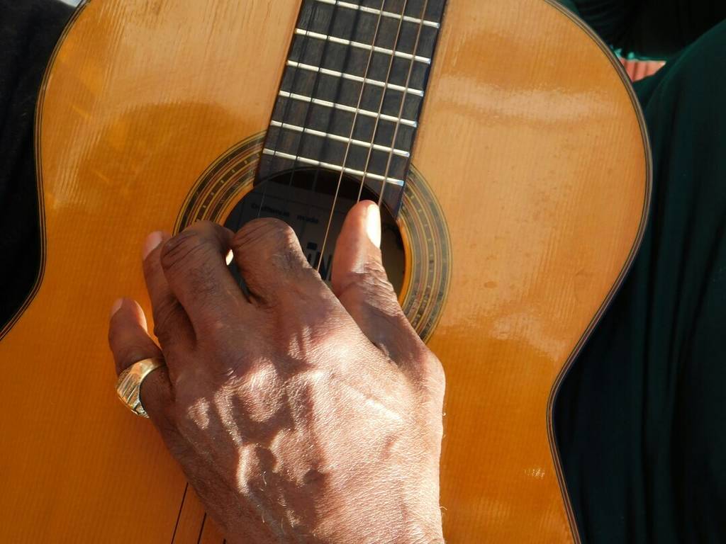 Bares con música en directo: plano detalle de mano tocando la guitarra flamenca