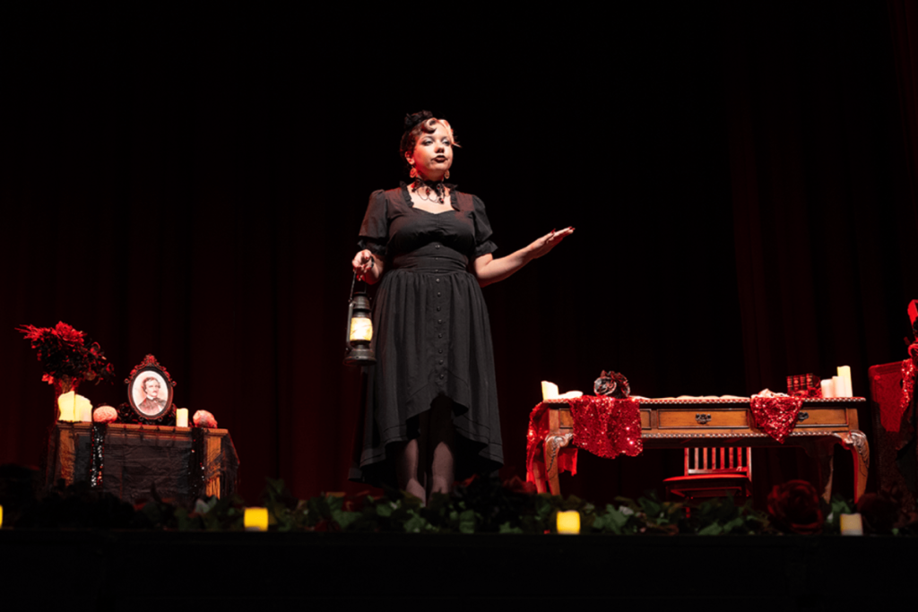 Une actrice en costume parle sur scène à l’Edgar Allan Poe Speakeasy.