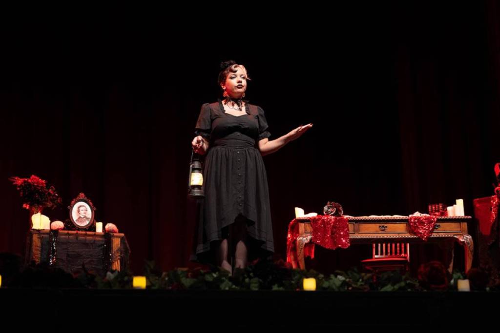 Plano general de una narradora sobre el escenario durante Edgar Allan Poe Speakeasy.