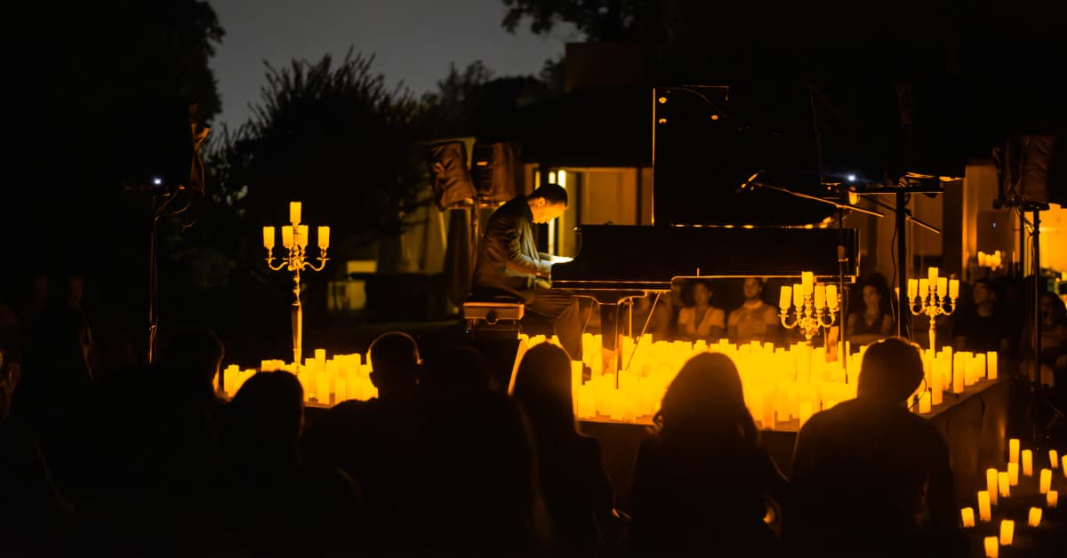 Un pianista che suona a un concerto all'aperto a lume di candela Candlelight Torino