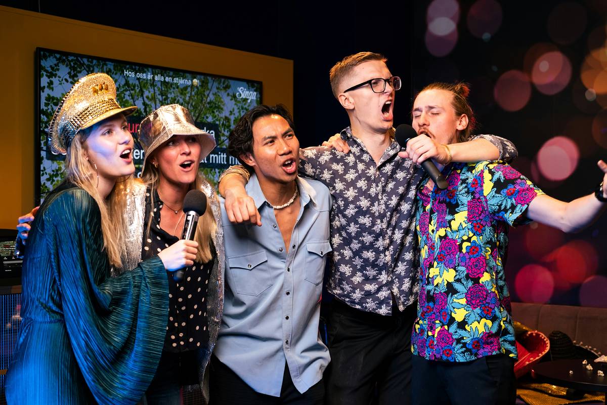 Photo d'un groupe d'amis chantant tous ensemble lors d'une session de karaoké