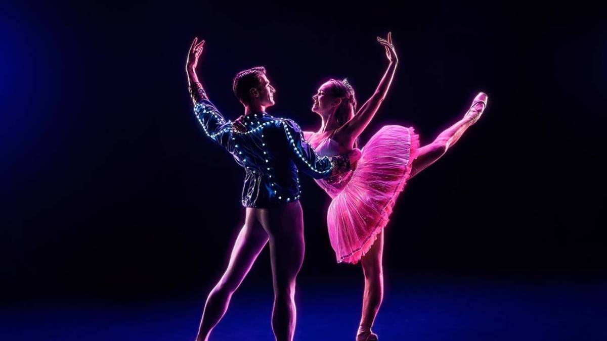 Deuc danseurs en costumes lumineux en pleine représentation