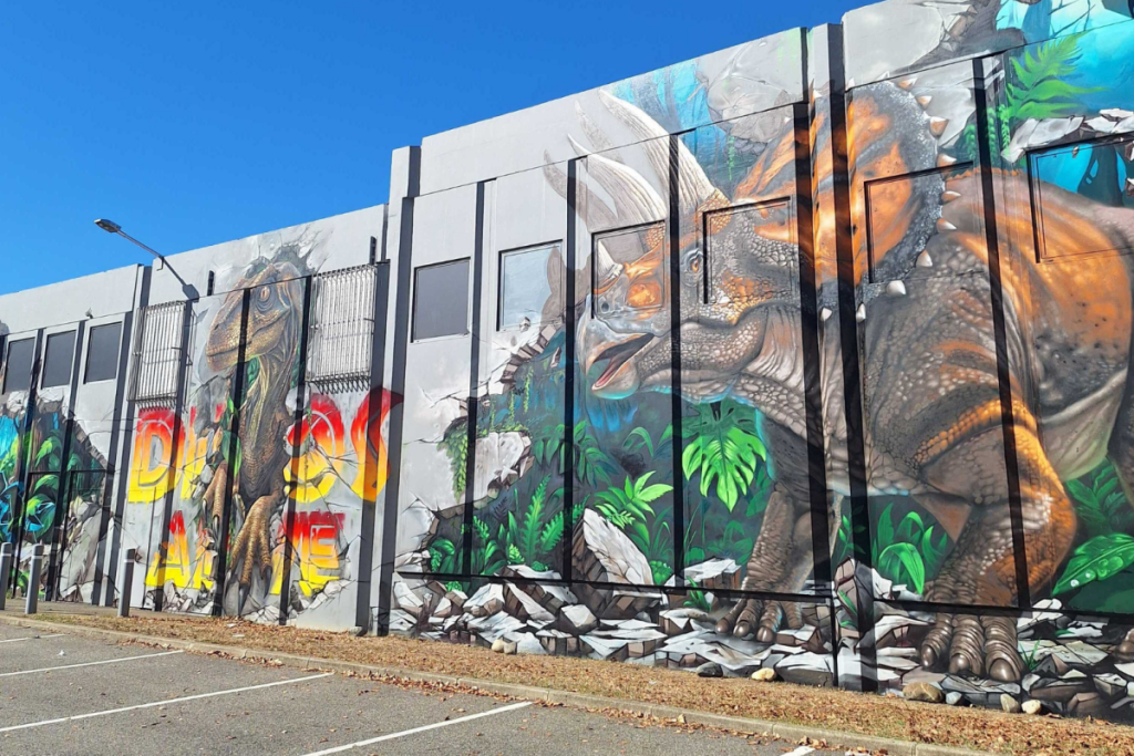 Photo d'une fresque de street art sur le mur extérieur de l'exposition Dinos Alive