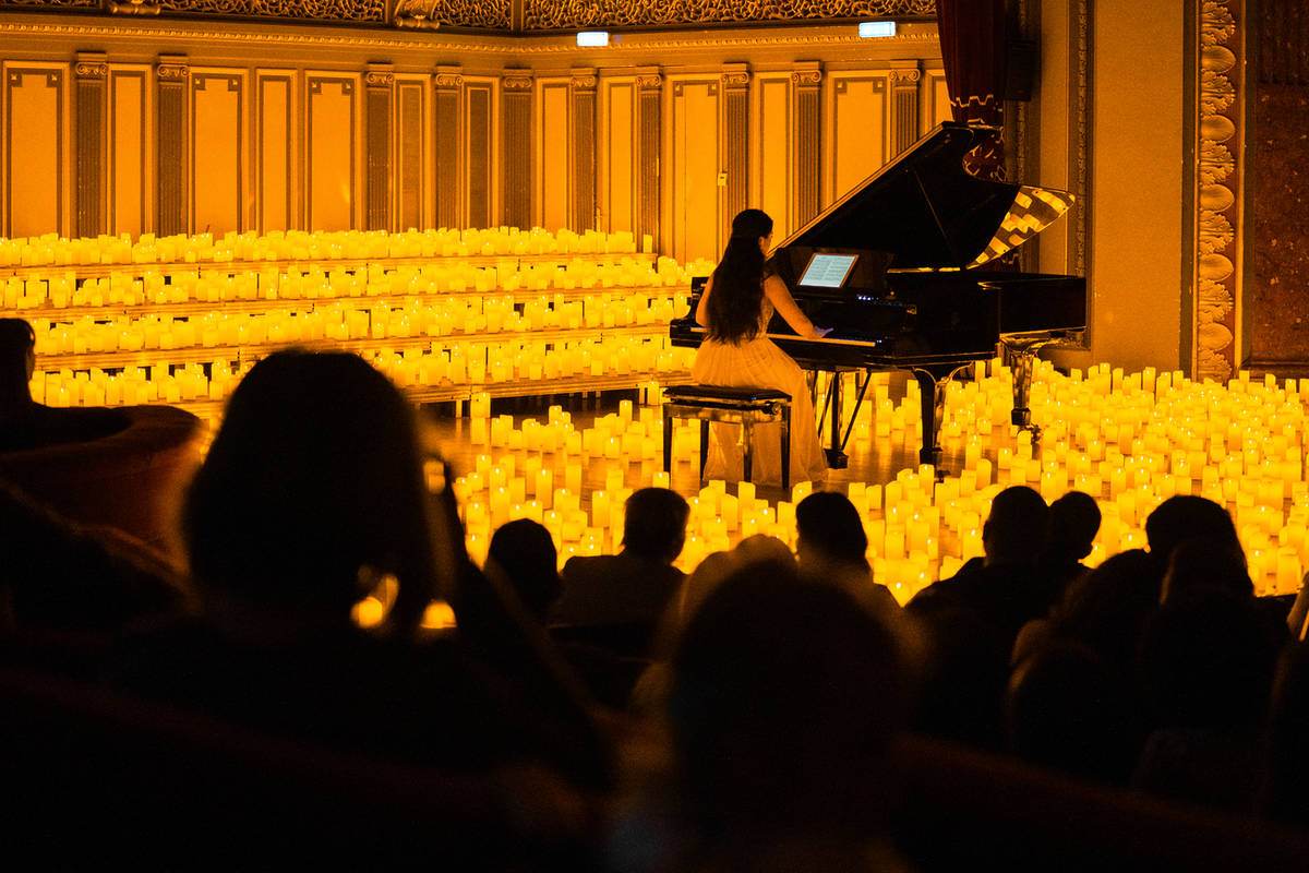 Pianista en un escenario lleno de velas durante un concierto Candlelight