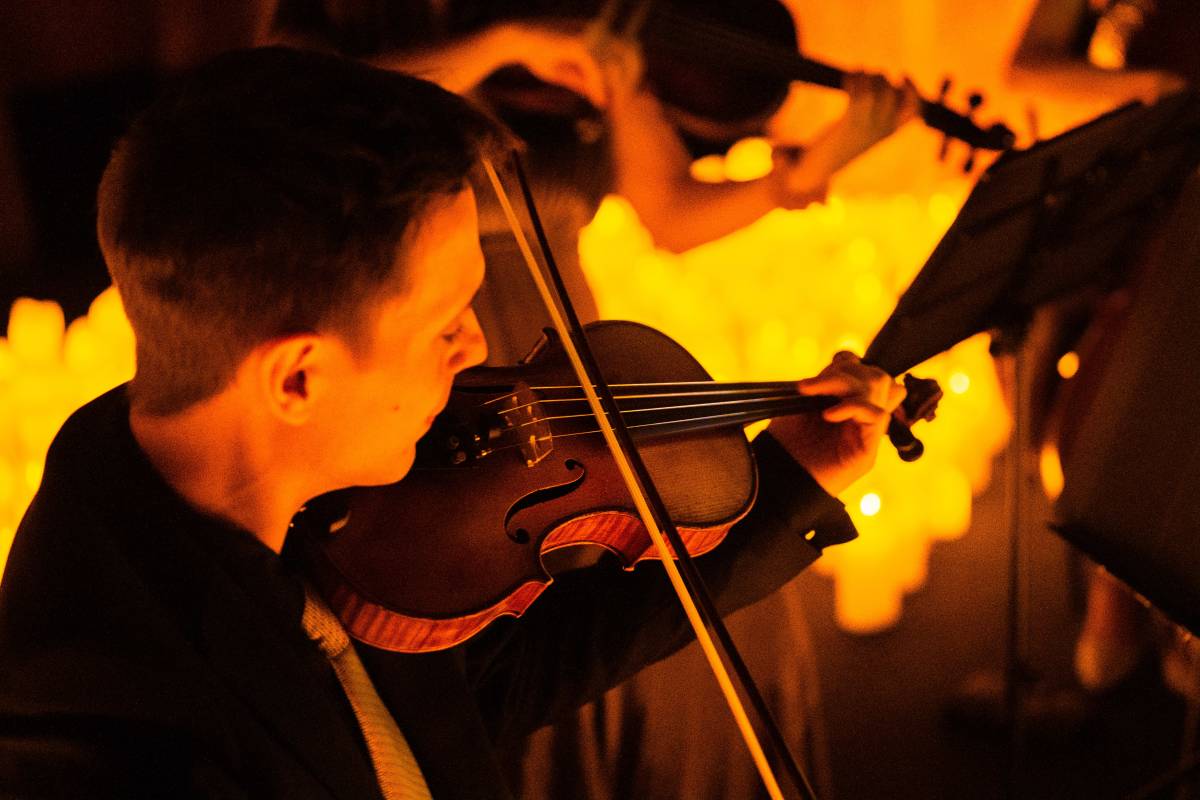 Primer plano de un músico tocando el violín durante un concierto Candlelight en Valencia.