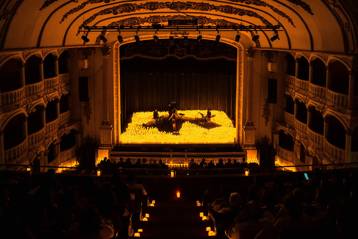 Plano general de un cuarteto de cuerda sobre un escenario cubierto de velas durante un concierto Candlelight.