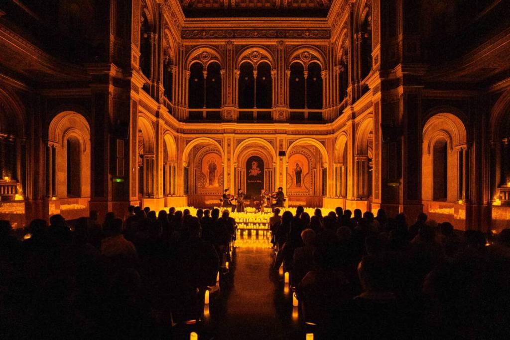Plano general del escenario del Centre Cultural La Beneficència cubierta de miles de velas durante un concierto Candlelight en Valencia.