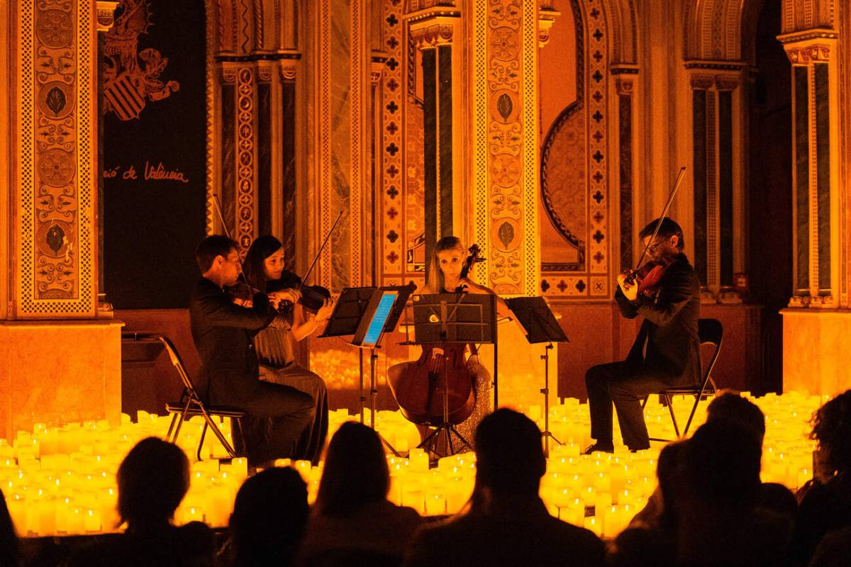 Un cuarteto de cuerda toca sobre un escenario cubierto de miles de velas durante un concierto Candlelight en el Centre Cultural La Beneficència en Valencia.