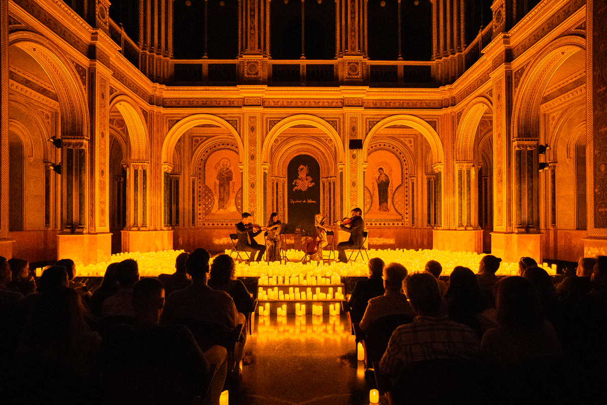 Concierto Candlelight en el Centre Cultural La Beneficència de Valencia, con cuarteto de cuerda rodeado de velas en un espacio histórico