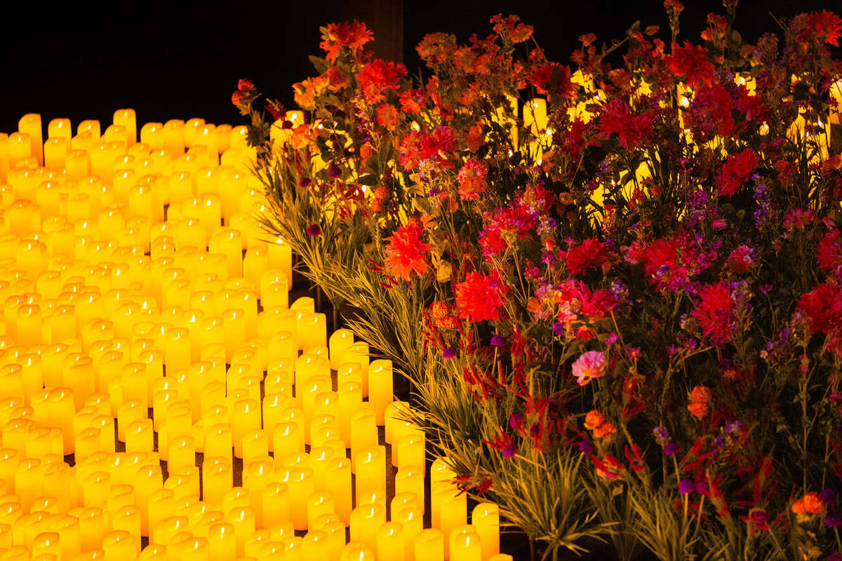 Primer plano de miles de velas y muchísimas flores de seda sobre el escenario durante un concierto Candlelight Spring.