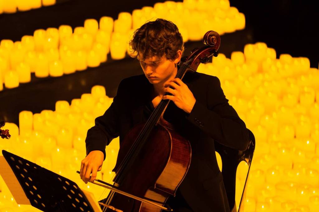Primo piano di un musicista che suona il violoncello durante un concerto Candlelight.