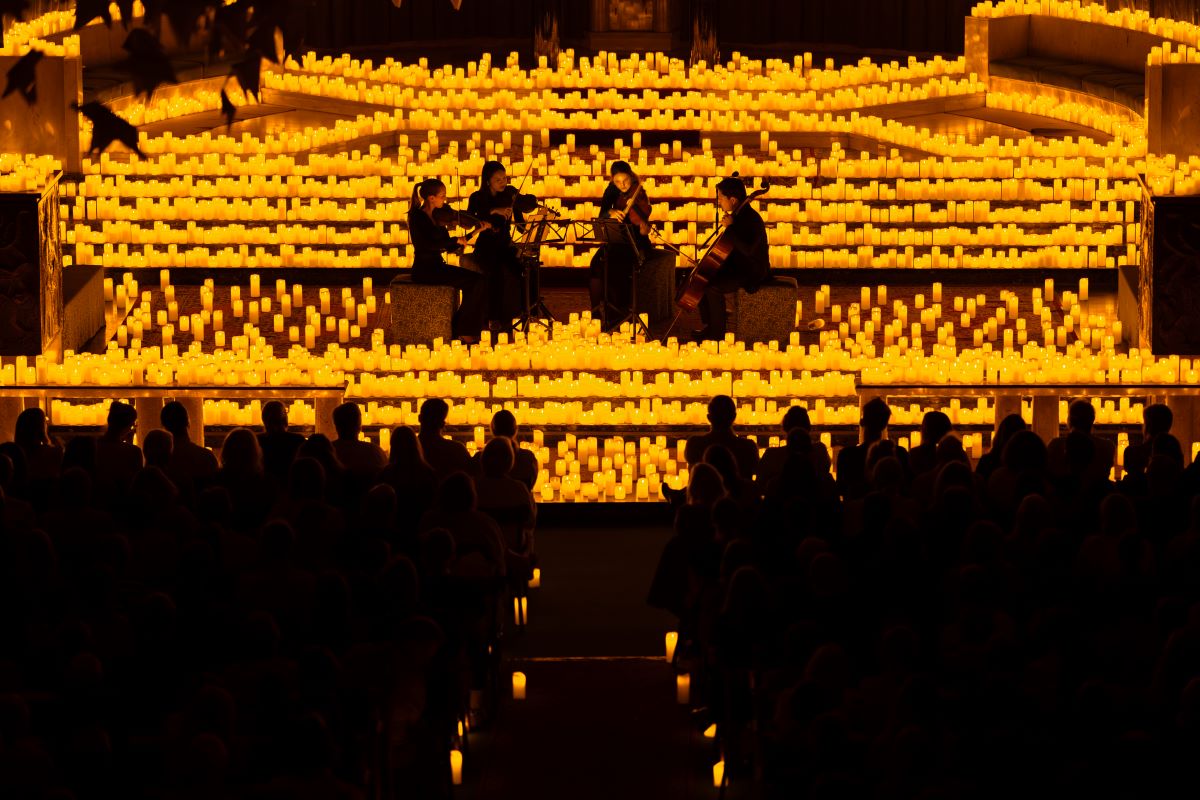 Streichquartett spielt auf der Bühne eines Candlelight-Konzertes zwischen zahlreichen Kerzen in der Canisiuskirche in Wien.