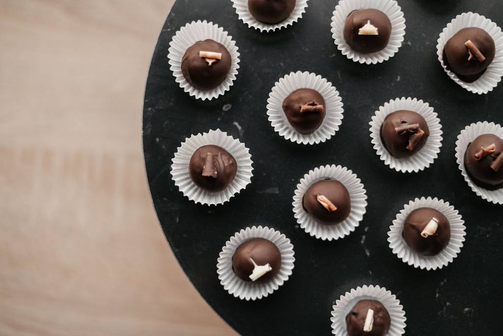 mehrere Schokoladen Pralinen auf einem Tisch nebeneinander