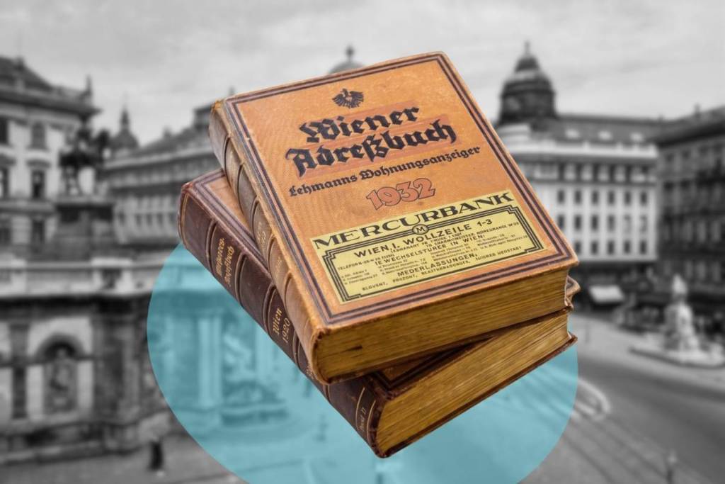 Printed editions of Adolph Lehmann’s historic 1932 Vienna address book stacked in front of a historic black-and-white photograph of downtown Vienna.