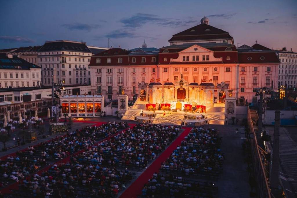 Ein weiter Panoramablick auf das riesige Open-Air-Spektakel des 4. Wiener Opernsommers vor dem Wiener Konzerthaus während der Abenddämmerung.