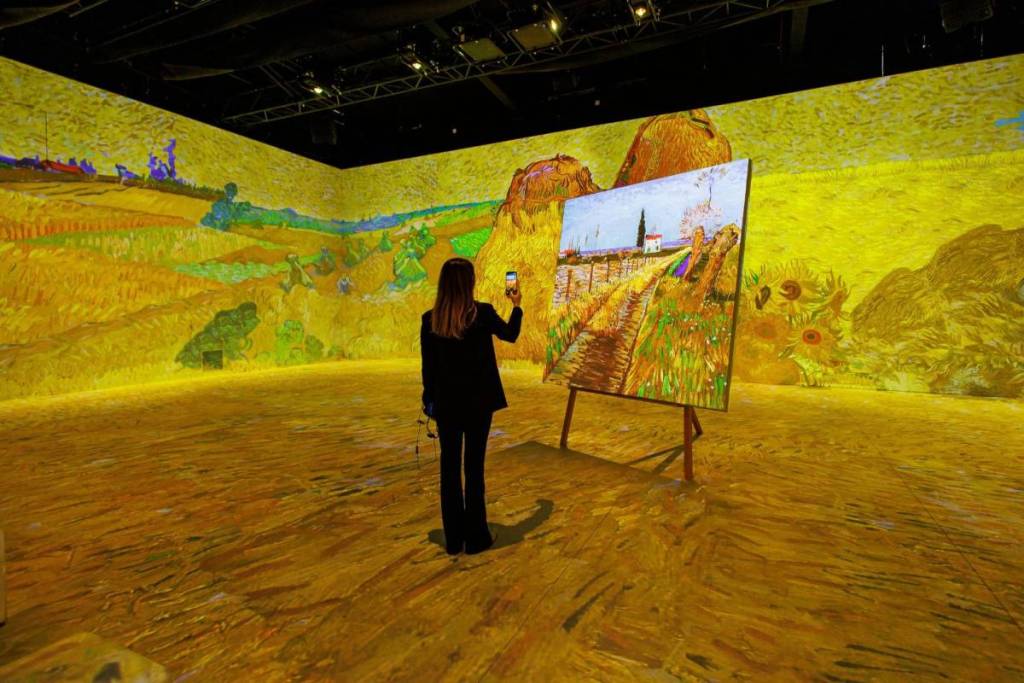 Eine Besucherin der Van Gogh Ausstellung in Wien steht in einem Kornfeld-Gemälde des Künstlers.