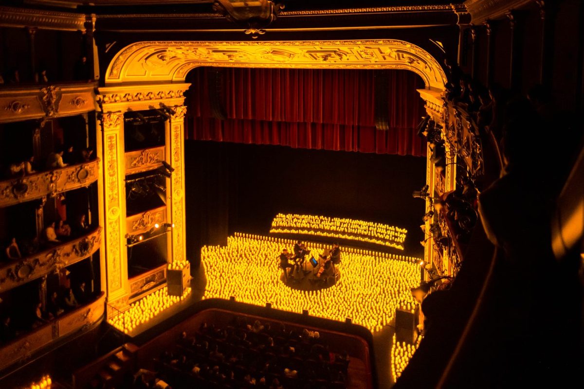 Plano general del escenario del Teatro Colón en Bogotá cubierto de miles de velas durante un concierto Candlelight.
