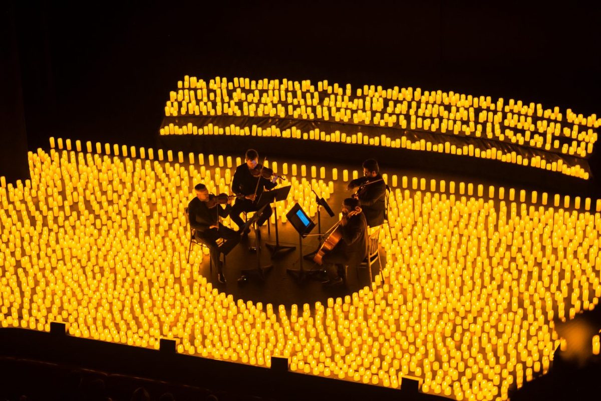 Un cuarteto de cuerda toca sobre un escenario cubierto de velas durante un concierto Candlelight en el Teatro Colón en Bogotá.